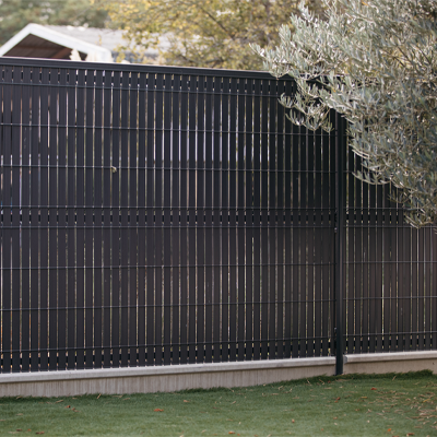 Clôture d'un jardin avec panneaux rigides et lames de clôture PVC