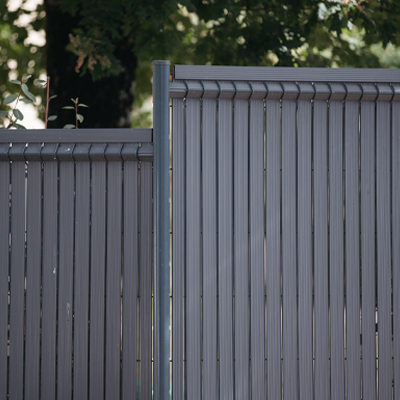Lames de clôture PVC glissées dans un panneau rigide